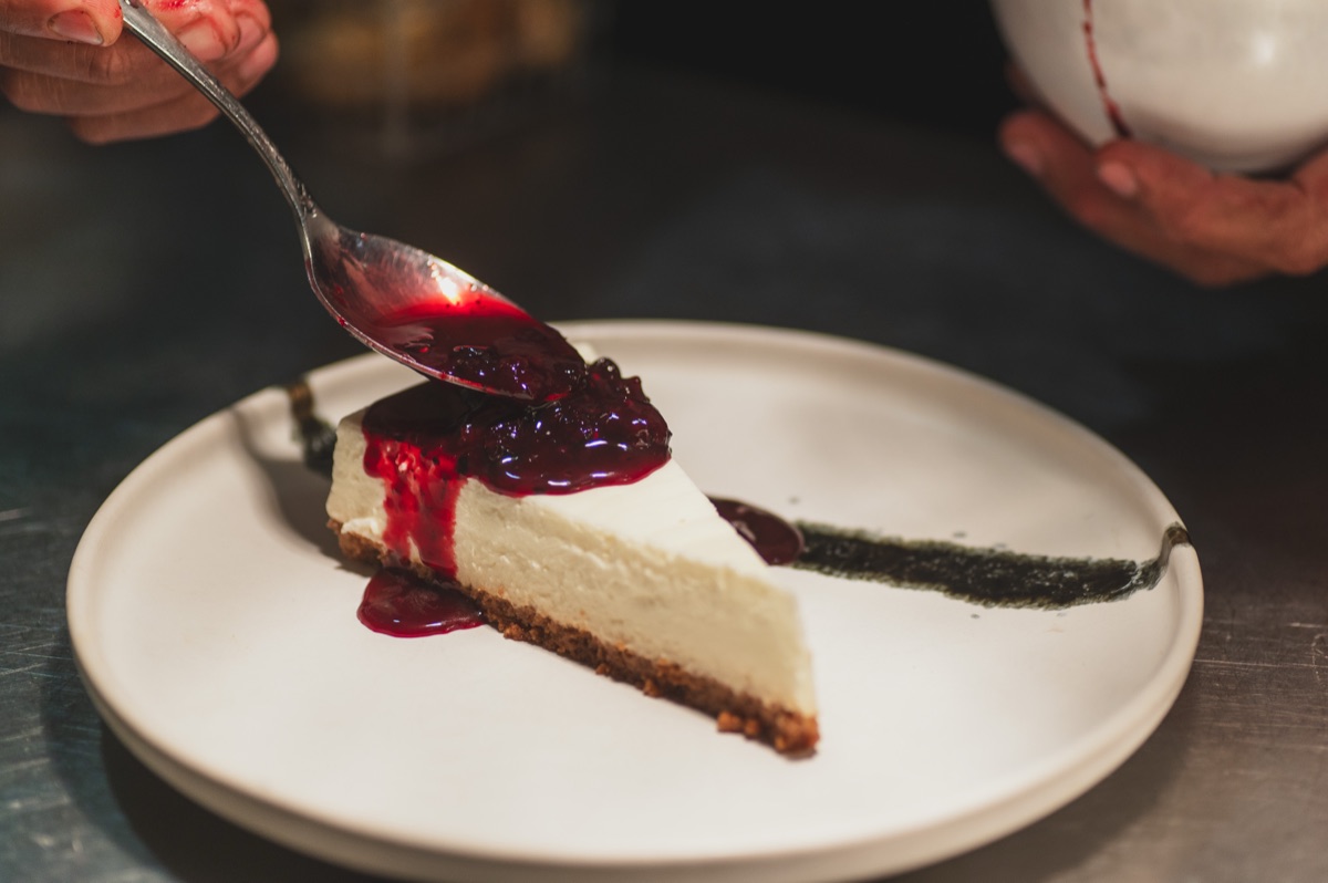 Cheesecake com molho de frutos vermelhos a ser servido